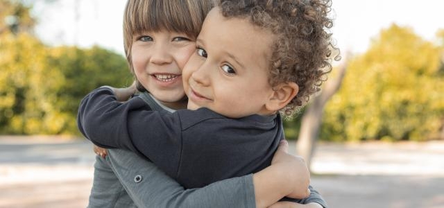 little boys outdoors hugging scaled