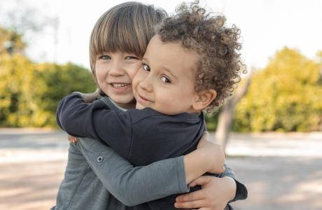 little boys outdoors hugging scaled